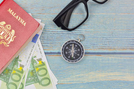 Passport and banknotes on wooden background. Vacation foreign travel or world tour budget plan.の写真素材