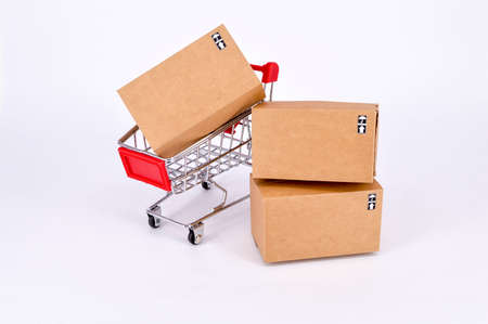 Online shopping concept.Shopping cart with cardboard boxes on white background. Selective focus.