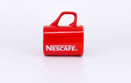 Puchong, Malaysia - February 24, 2019; Promotional red Nescafe mug on white background. Selective focus.のeditorial素材