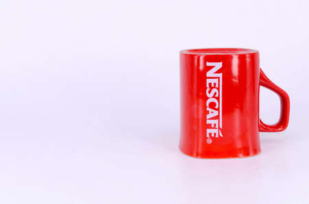 Puchong, Malaysia - February 24, 2019; Promotional red Nescafe mug on white background. Selective focus.のeditorial素材