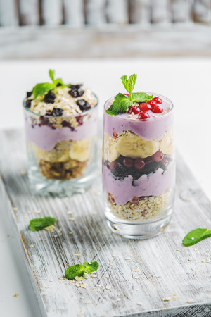granola in a glass with yogurt and berries on a white backgroundの写真素材