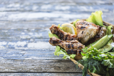 grilled chicken with green salad leaf, cucumber, onion on light wooden background close-upの写真素材