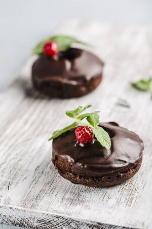 chocolate donuts with raspberries on a light background top view with copyspaceの写真素材