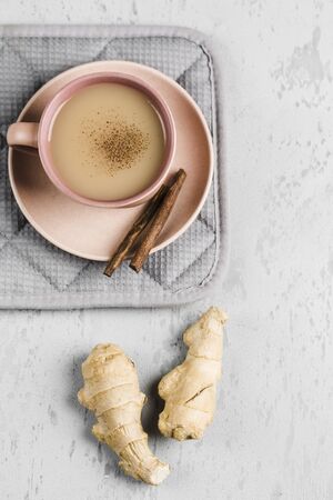 Tea masala in a Cup on the plate with the winter spices of cinnamon and ginger on a light background top view with copyspaceの写真素材