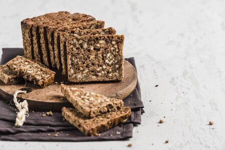 Gluten-free bread with hazelnut and flax seeds on a wooden Board on a white background close-up. Food for diet and health.の写真素材