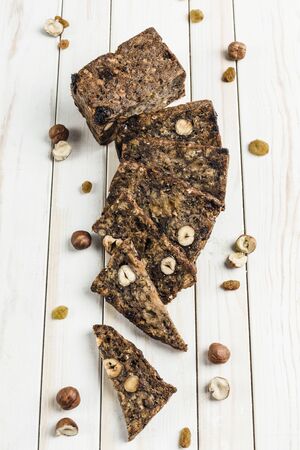 Gluten-free bread with hazelnut and flax seeds on a wooden Board on a white background close-up. Food for diet and health.の写真素材