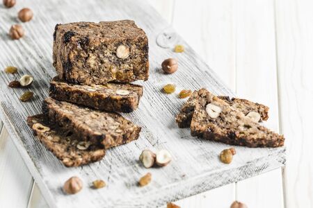 Gluten-free bread with hazelnut and flax seeds on a wooden Board on a white background close-up. Food for diet and health.の写真素材