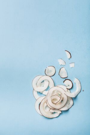 Coconut chips on a blue background, flatlay, a natural product for healthy nutrition.の写真素材