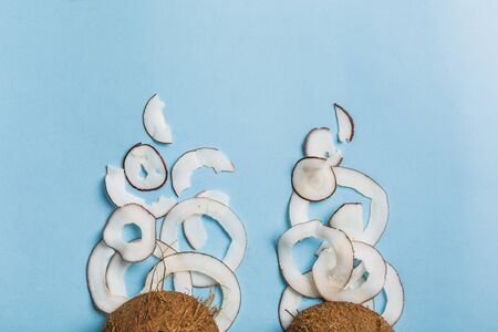 Coconut chips in a bowl of coconut on a blue background, flatlay, a natural product for healthy nutrition. Concept.の写真素材