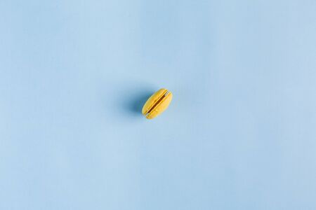 Multicolored macaroons on a blue background, top view, Flatley with copy space. Dessert with melon, lemon and raspberry flavor. Artの写真素材