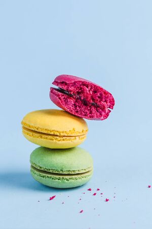Colorful macaroons on a blue background, close-up, Flatley with copy space. Dessert with melon, lemon and raspberry flavor. Artの写真素材