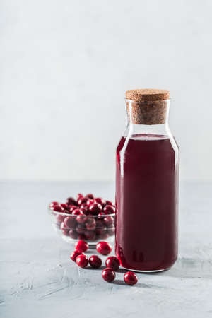The concept of a summer refreshing drink made from red berries: berry Morse made from fresh strawberries and cranberries is a great drink to quench your thirst on a light background with a copy space. Vertical orientation.の写真素材