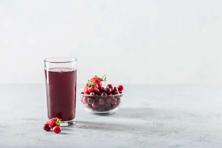 The concept of a summer refreshing drink made from red berries: berry Morse made from fresh strawberries and cranberries is a great drink to quench your thirst on a light background with a copy space. Horizontal orientation.の写真素材