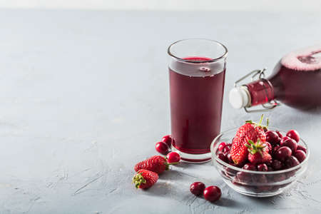 The concept of a summer refreshing drink made from red berries: berry Morse made from fresh strawberries and cranberries is a great drink to quench your thirst on a light background with a copy space. Horizontal orientation.の写真素材