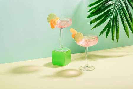 Alcohol Margarita cocktail with ice frappe, a slice of lime and orange zest on a tropical background with copyspace. Horizontal orientation.の写真素材