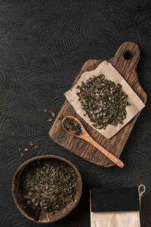Hemp flakes in a coconut bowl for healthy food on a wooden Board on a black background. Flat lay whith copy space. Cannabis food concept. Horizontal orientation.の写真素材
