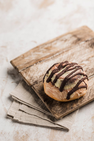 Sinabon bun with chocolate on a wooden Board with a napkin on a light background. Close-up with a copy space. Vertical orientation. American classic bun.の写真素材