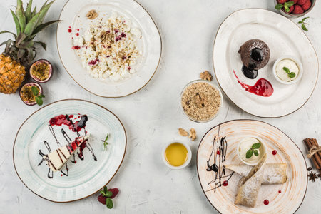 Several dishes with desserts on plates, cheesecake, chocolate muffin, strudel and cottage cheese served by the chef on a light background, top view with a copy space. flat lay. The concept of Breakfast. Restaurant food.の写真素材