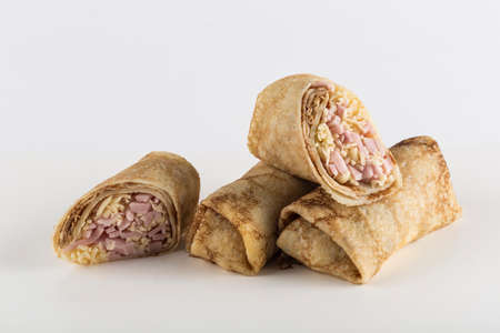 Multiple pancakes stuffed with bacon and cheese on a white background close-up with a copy space for the text, isolated. Traditional food for the Maslenitsa holiday. Horizontal orientation.の写真素材
