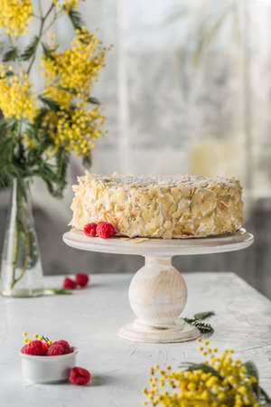 Napoleon puff cake with berry filling on a wooden stand. On the background of the home interior, a side view with a copy space for text. Russian birthday cake. Vertical orientation.の写真素材