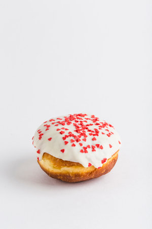 Donut with white chocolate icing and confiture on a white background, isolated. Close-up with a copy space for the text. Delicious and sweet dessert.の写真素材