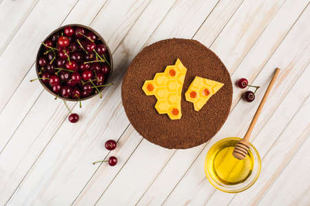 Honey cake with cherries on a white wooden background. Top view with a copy space for the text....