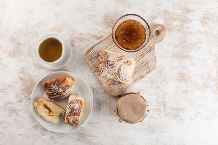 Sweet freshly baked bun with jam on a white wooden board is cut into pieces. Top view with a copy space for the text. Horizontal orientation.の写真素材
