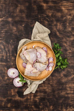 Freshly cooled chicken thighs with red onions and herbs on a dark wooden background. Top view with a copy space. Horizontal orientation.の写真素材