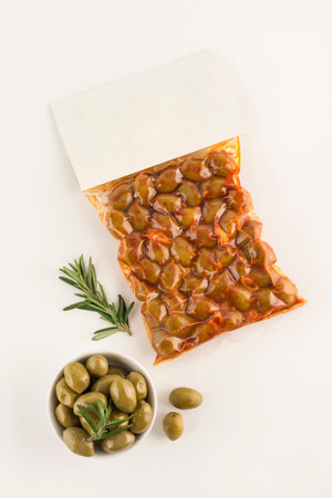 Pickled olives with paprika spices in a vacuum package with a place for the label on a light background. Top view with a copy space for text. Vertical orientation.の写真素材