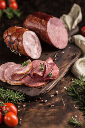 A set of chopped pork on a wooden board cut into pieces lies on a wooden board with a dark background. Side view. Vertical orientation with a copy space for the text.の写真素材