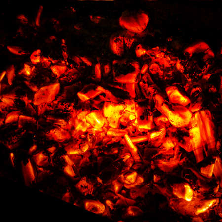 Background of burning hot coals, actively smoldering embers of fire, BBQ Grill Pit With Glowing And Flaming Hot Charcoal Briquettes, Food Background Or Texture, Close-Up, Top Viewの写真素材