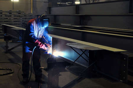 electric welder brews steel at the factory. Sparks, smoke