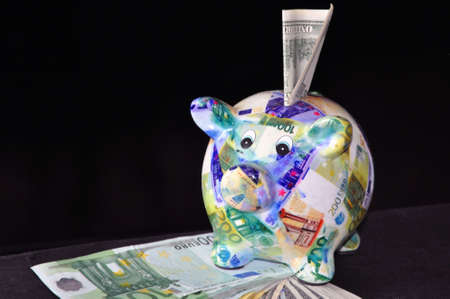 Piggy bank with banknotes drawings on a blackの写真素材