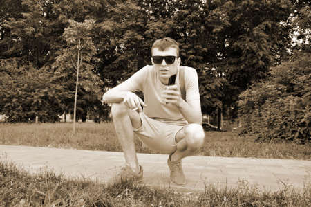 Handsome young man. half-smoking smokes and holds the smartphone in hand