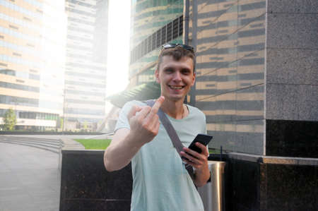 Handsome young man. Shows the middle finger of the right hand