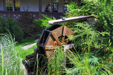 Landscape and arrangement. Driving mill wheel with falling water in the garden.の写真素材