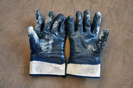 Blue protective gloves are stained with paint. Personal Hand Protection