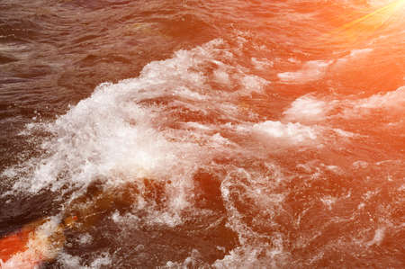 Water of a fast mountain river with rapids.