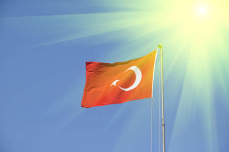 National state symbols. Flag of Turkey on a background of blue sky.