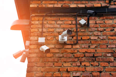 closed circuit camera Multi-angle CCTV system. a row of cameras hung on an old brick wall. securityの写真素材