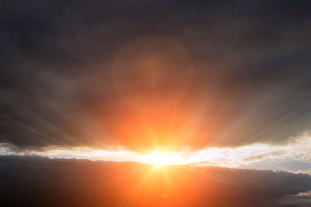 Red clouds in the rays of the setting sun. Flare