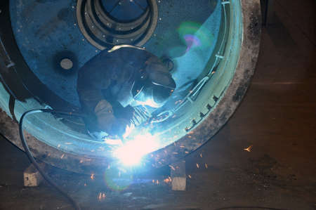 Professional welder welds an industrial tank in a workshop. Industryの写真素材
