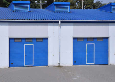Blue rolling gates at the entrance to the warehouse building. Industryの写真素材