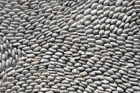 The sidewalk or wall of small pebbles lined with a pattern. Art Wallpaper, Abstract Background,...