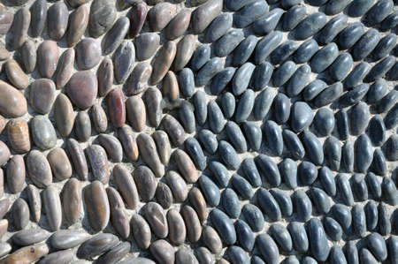 The sidewalk or wall of small pebbles lined with a pattern. Art Wallpaper, Abstract Background,...