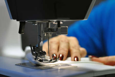 Sewing machine. At work, a girl with a beautiful manicure in her hands. Hobbyの写真素材