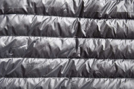 Background and texture of black autumn clothes made of bologna, up of clothes. Stitches on the fabric.の写真素材