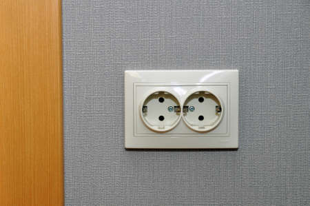 Single empty electrical outlet on a gray wall by the doorway. Europeの写真素材