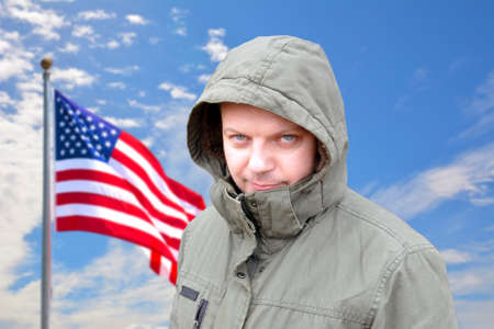 American man on a background of blue sky with a developing flag. American flag. Proud American. USA....