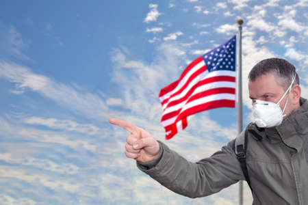 American man against the blue sky with a developing flag.の写真素材